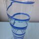 Glass vase on a pedestal with a blue trim.