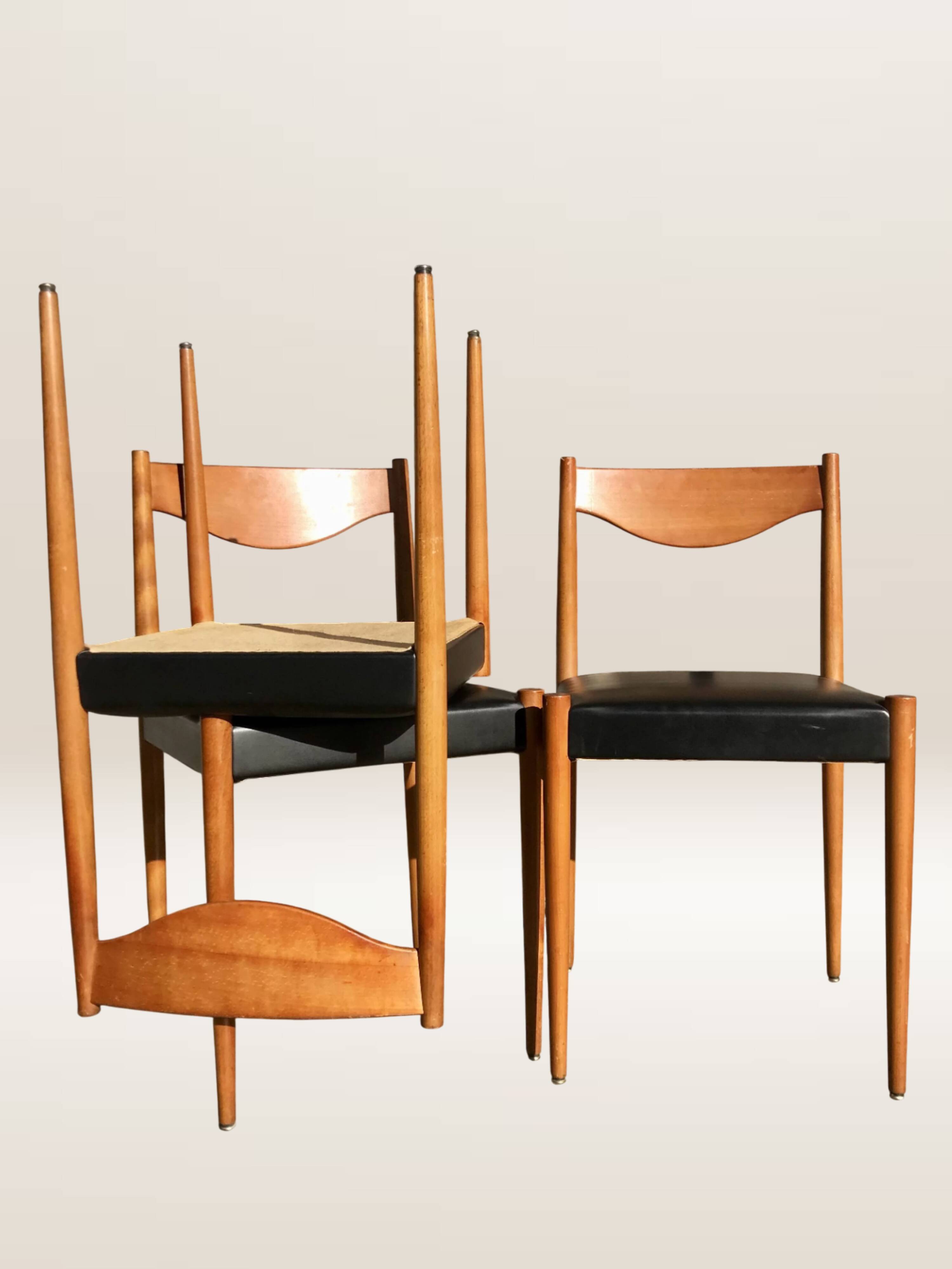 Set of 6 modernist chairs with black faux leather seats.