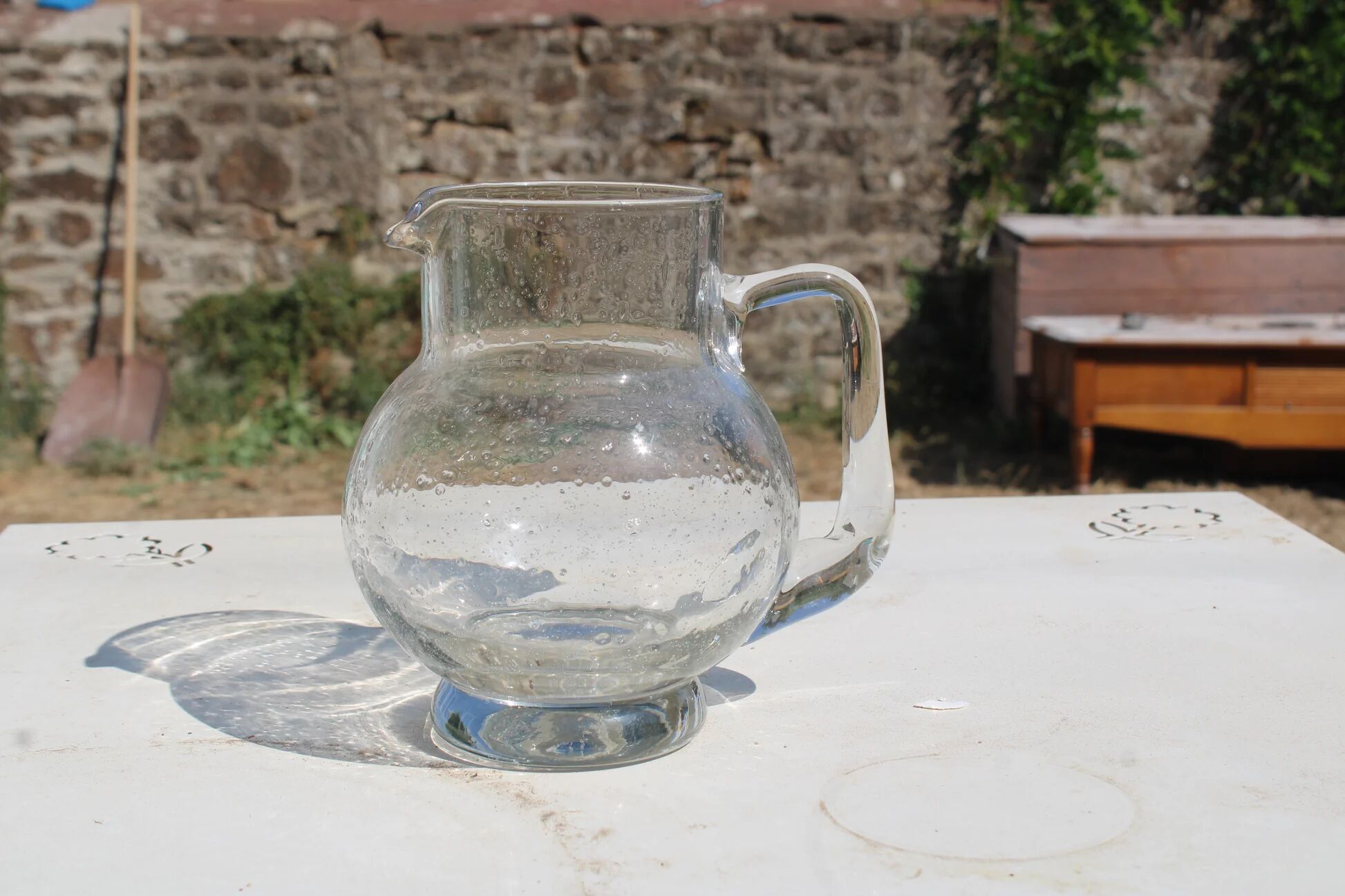 Vintage blown glass pitcher with bubbles, transparent.
