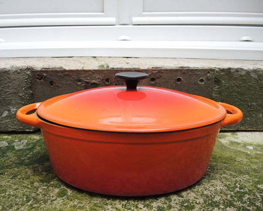Old oval casserole in orange enamelled cast iron