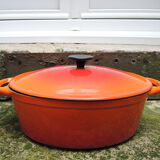 Old oval casserole in orange enamelled cast iron
