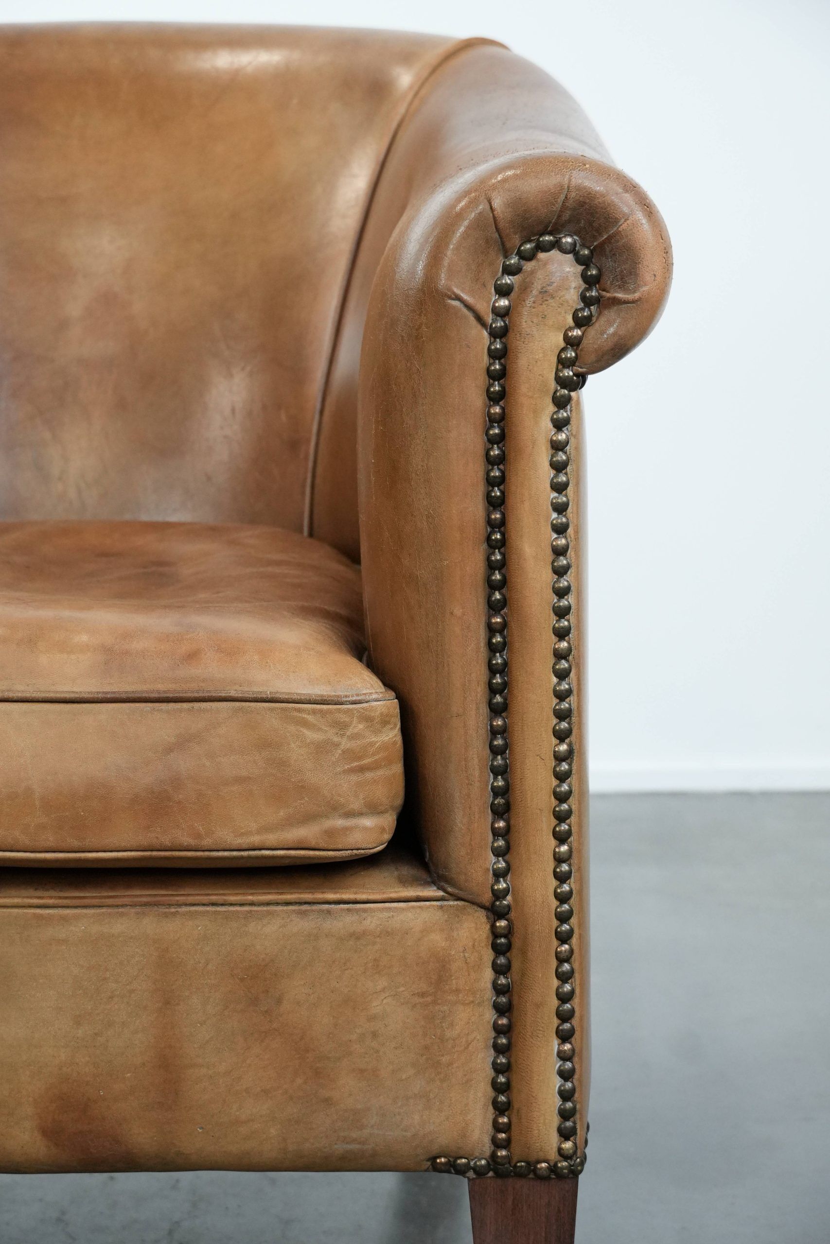 Characterful club chair made of sheepskin leather with light cognac colours