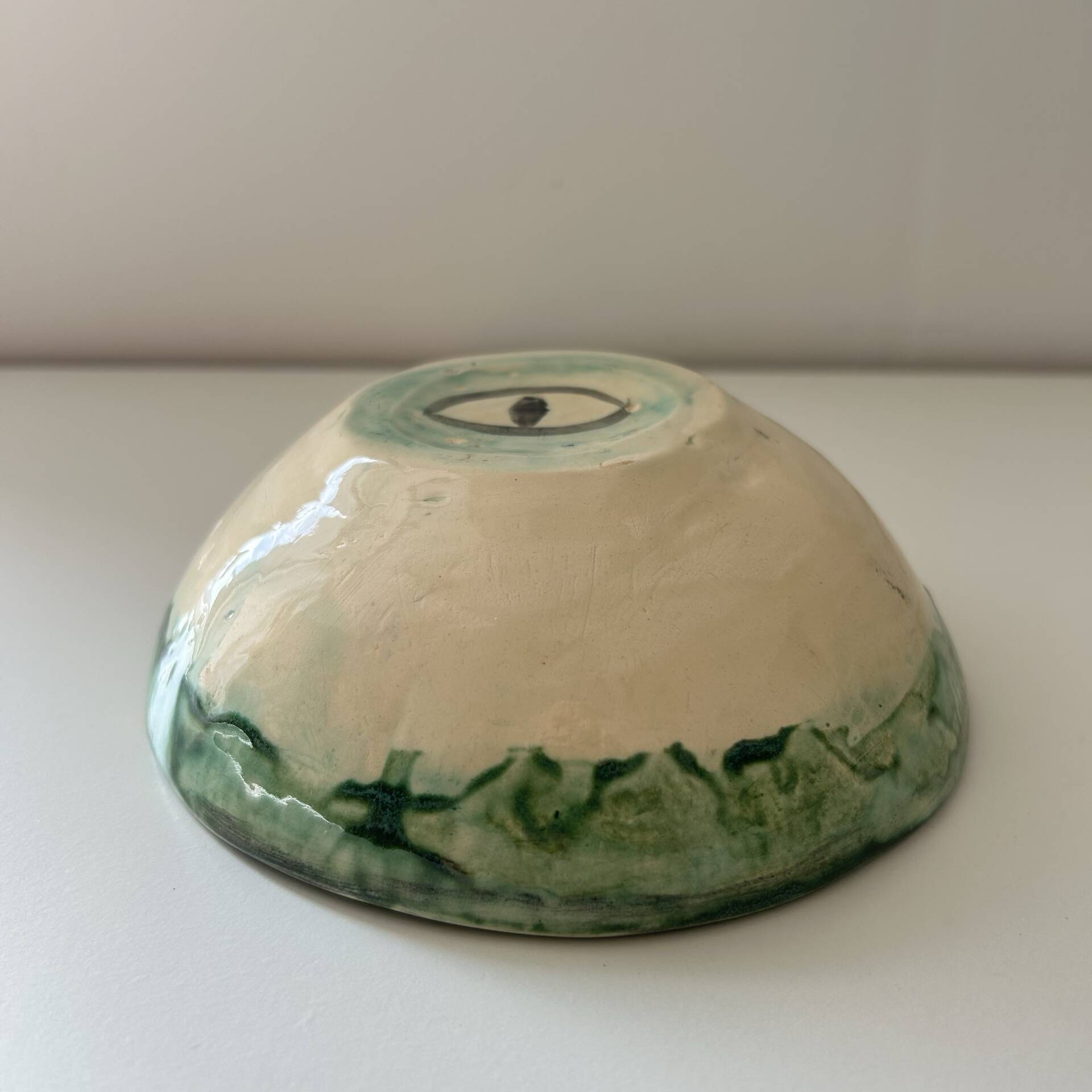 Green bowl signed with an eye