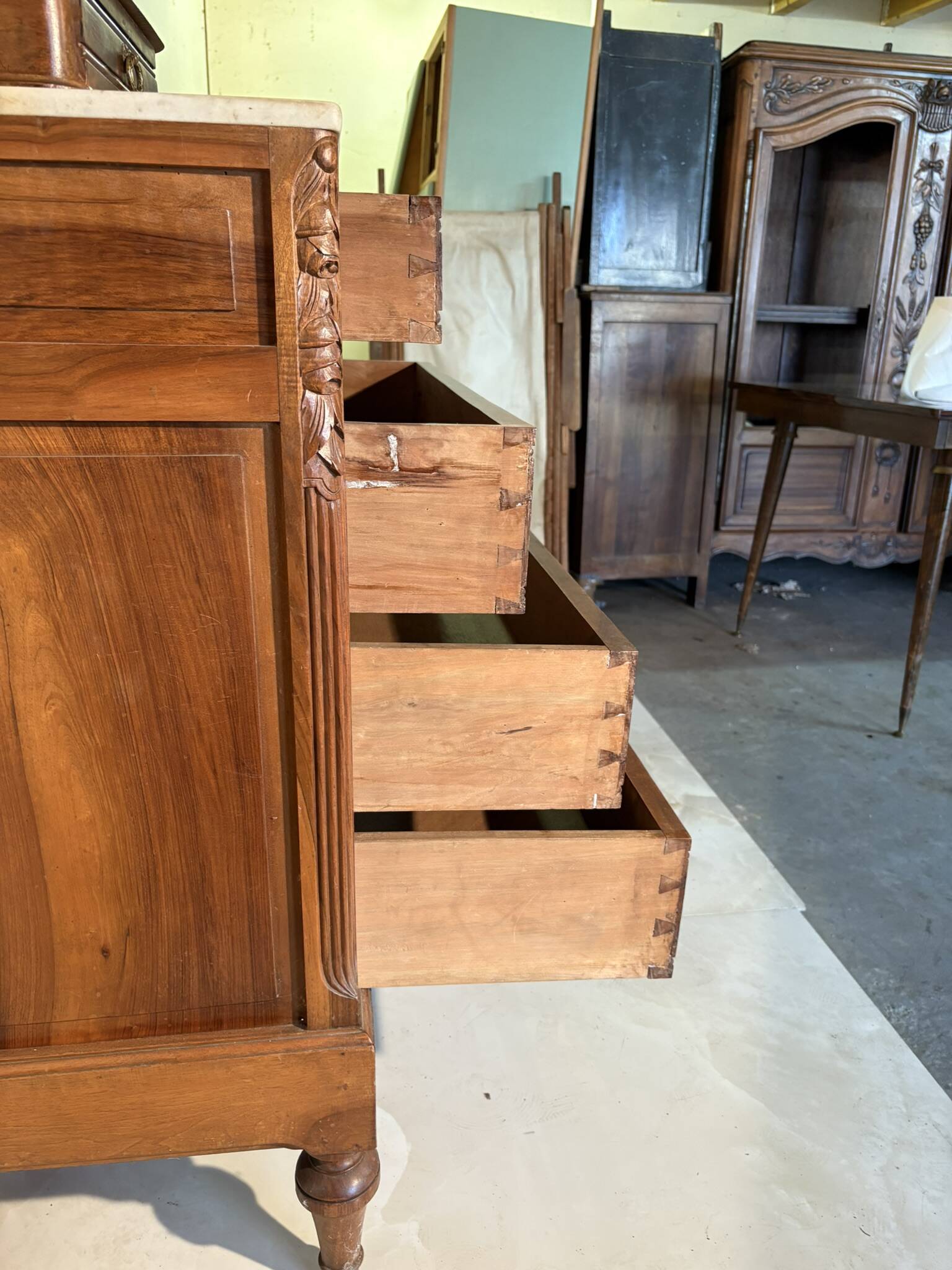 Antique carved wooden dressing table with marble and tilting oval mirror.