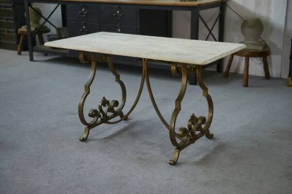 Side table with a gilt wrought iron base attributed to Gilbert Poillerat, with a travertine top, 1940s
