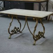 Side table with a gilt wrought iron base attributed to Gilbert Poillerat, with a travertine top, 1940s