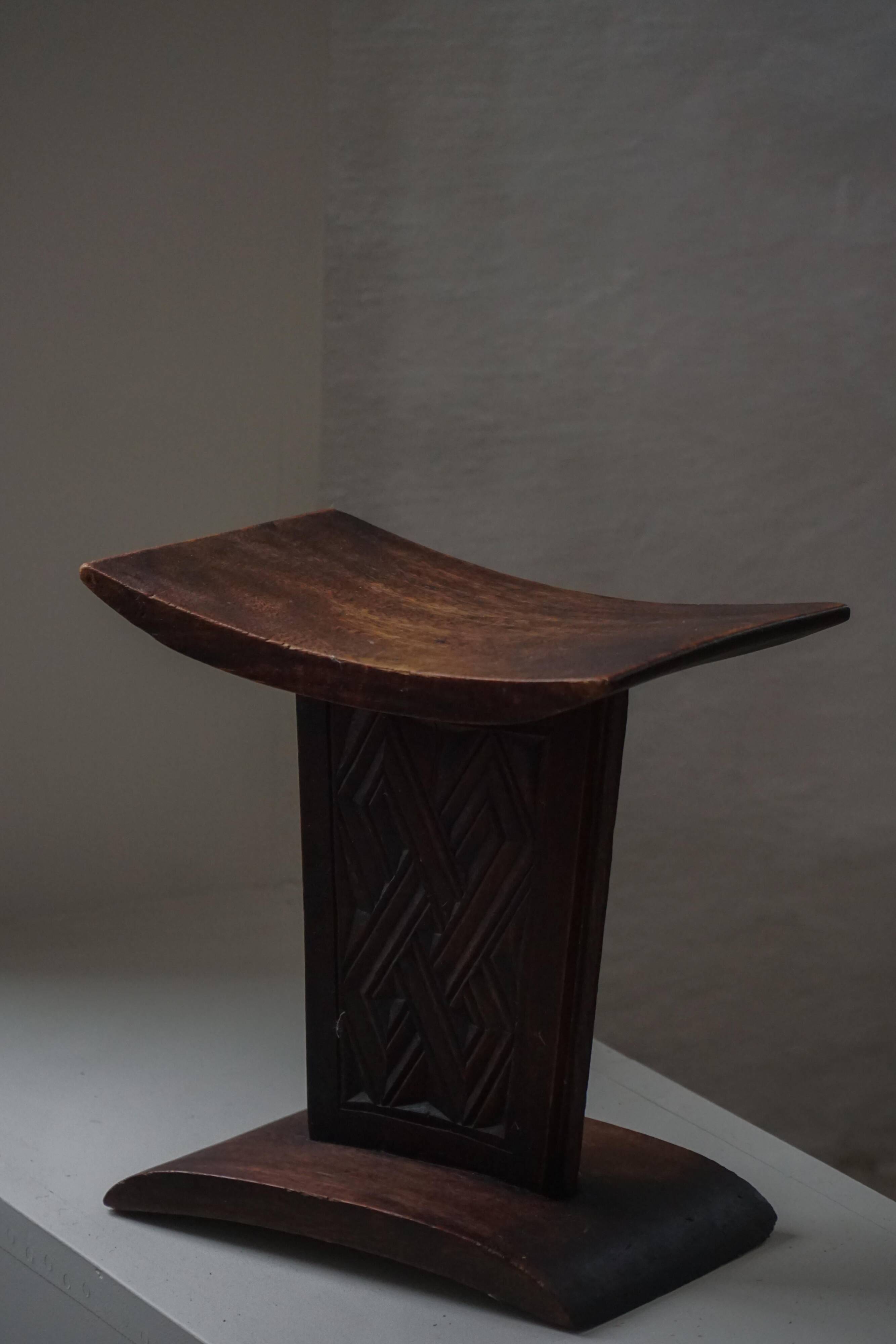 Sculptural African stool in hardwood, curved seat and architectural base, 1970s.