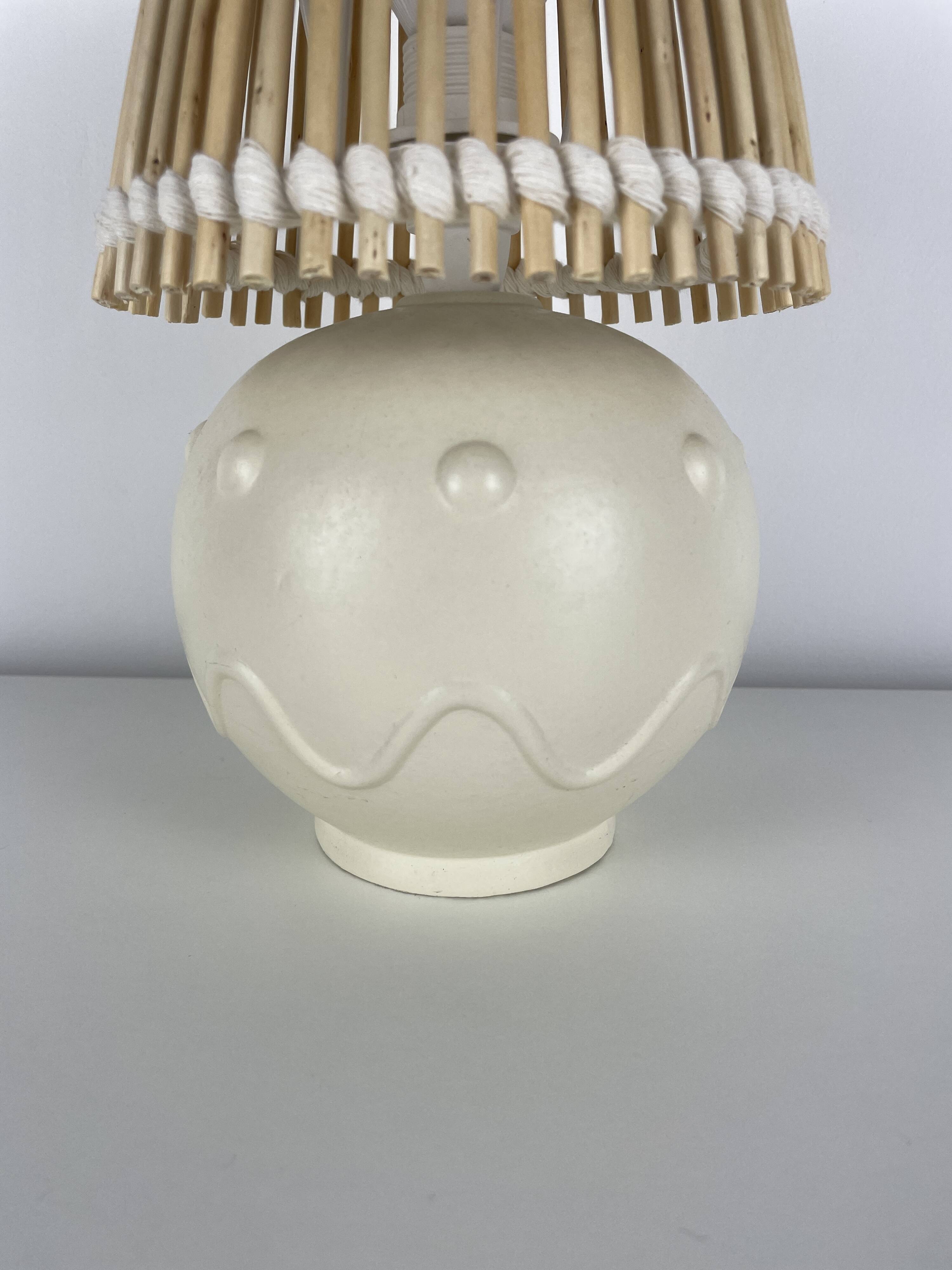 Vintage ceramic lamp with wicker and cotton shade.