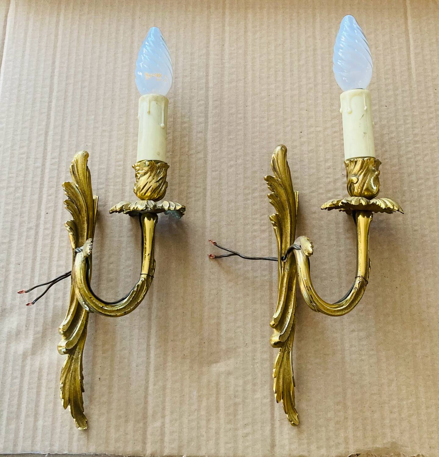 Bronze wall lights in the Louis XV style with curved branches and leaf decorations.