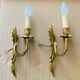Bronze wall lights in the Louis XV style with curved branches and leaf decorations.