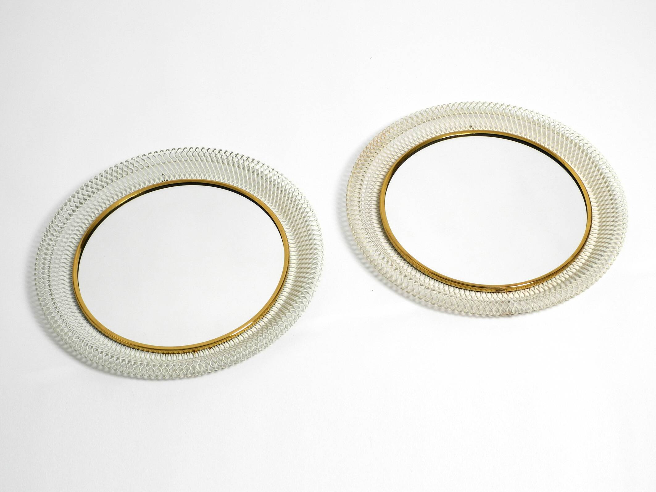 Pair of Mid Century wall mirrors with brass rim and white metal frames