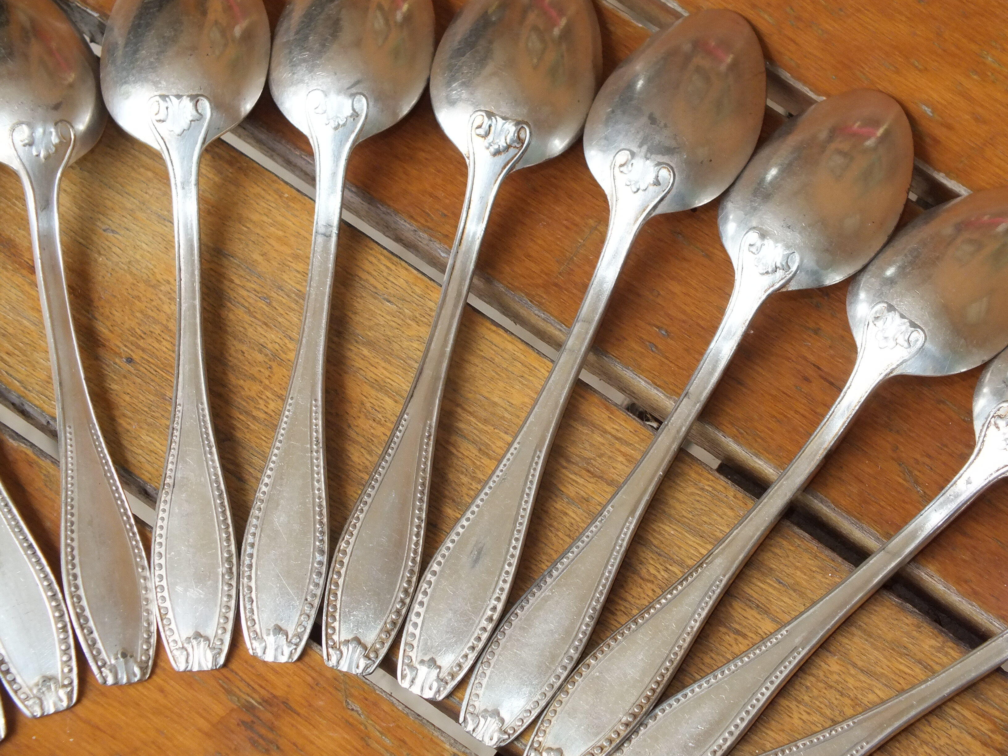 15 small silver metal spoons with rows of beads