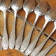 15 small silver metal spoons with rows of beads