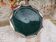 Round oriental hollow dish in deep green ceramic and silver colored metal