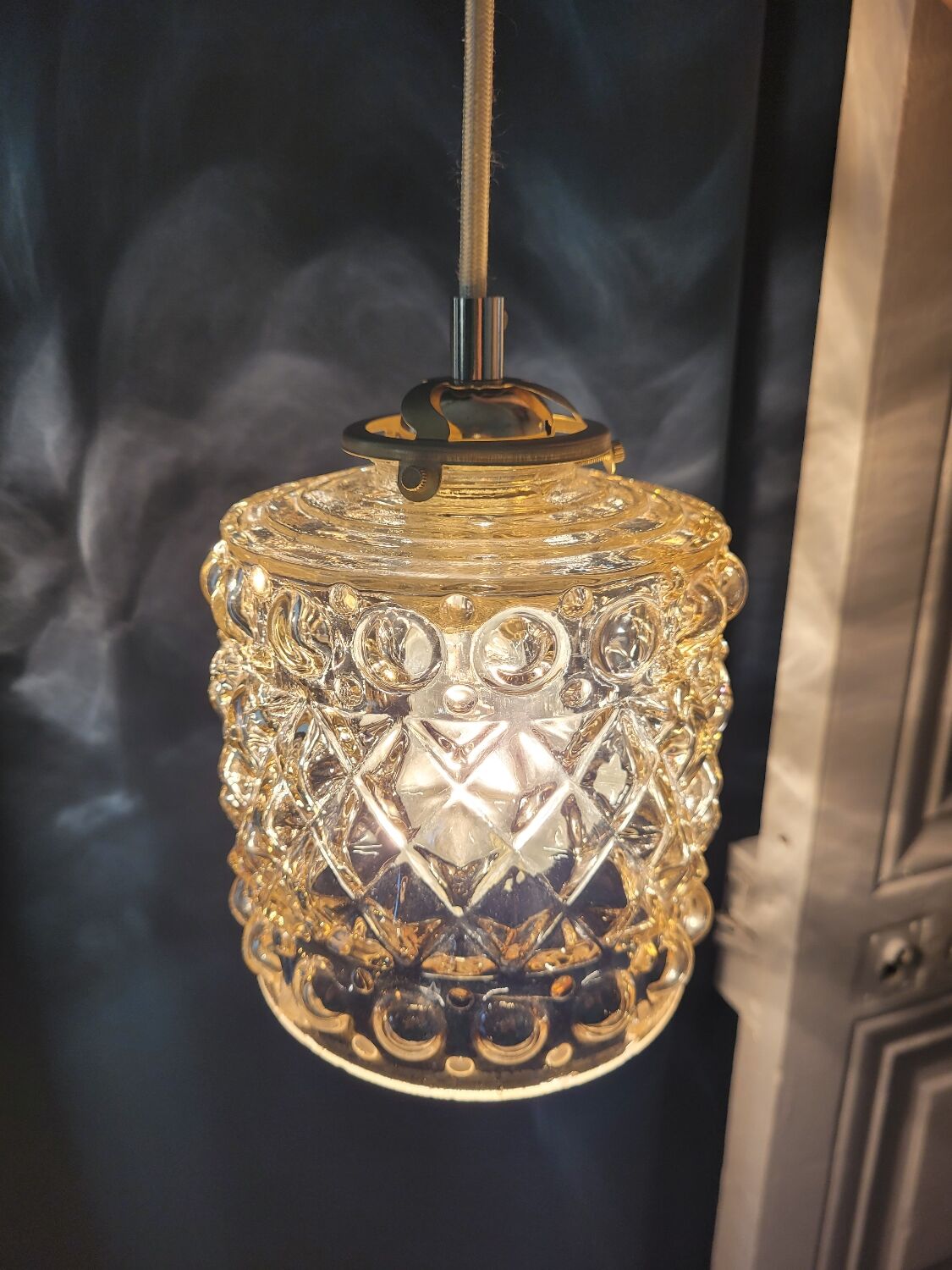 Moulded glass lamp with a cubic-spherical relief design.