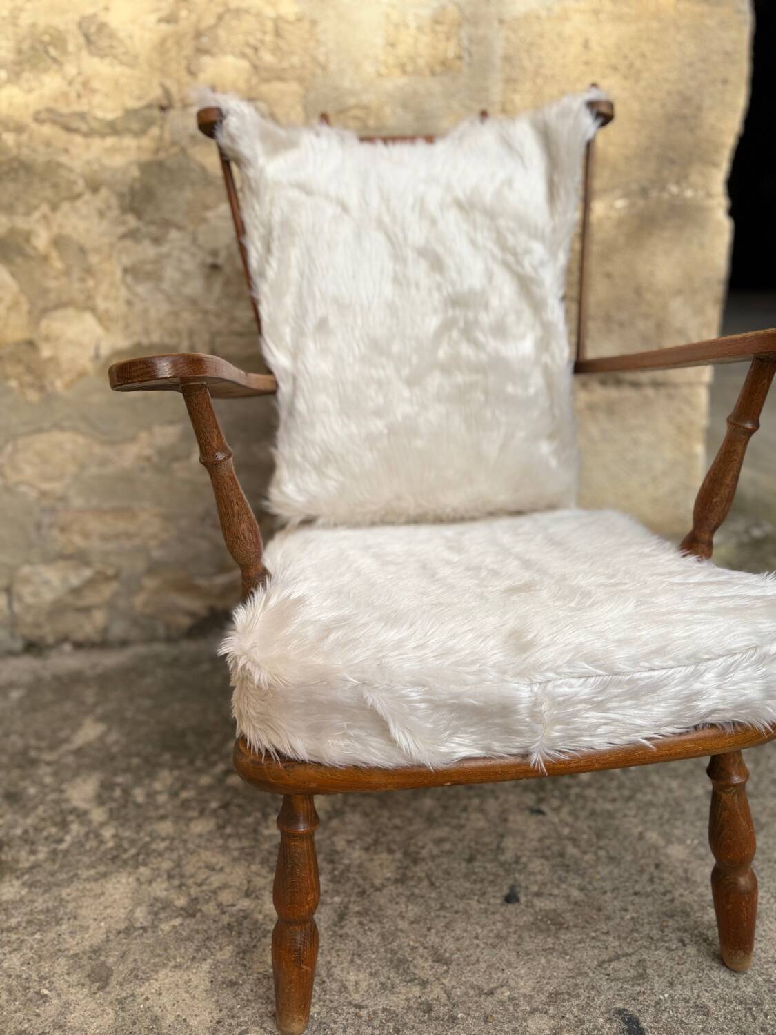 Scandinavian armchair in solid wood with beige fur cushion