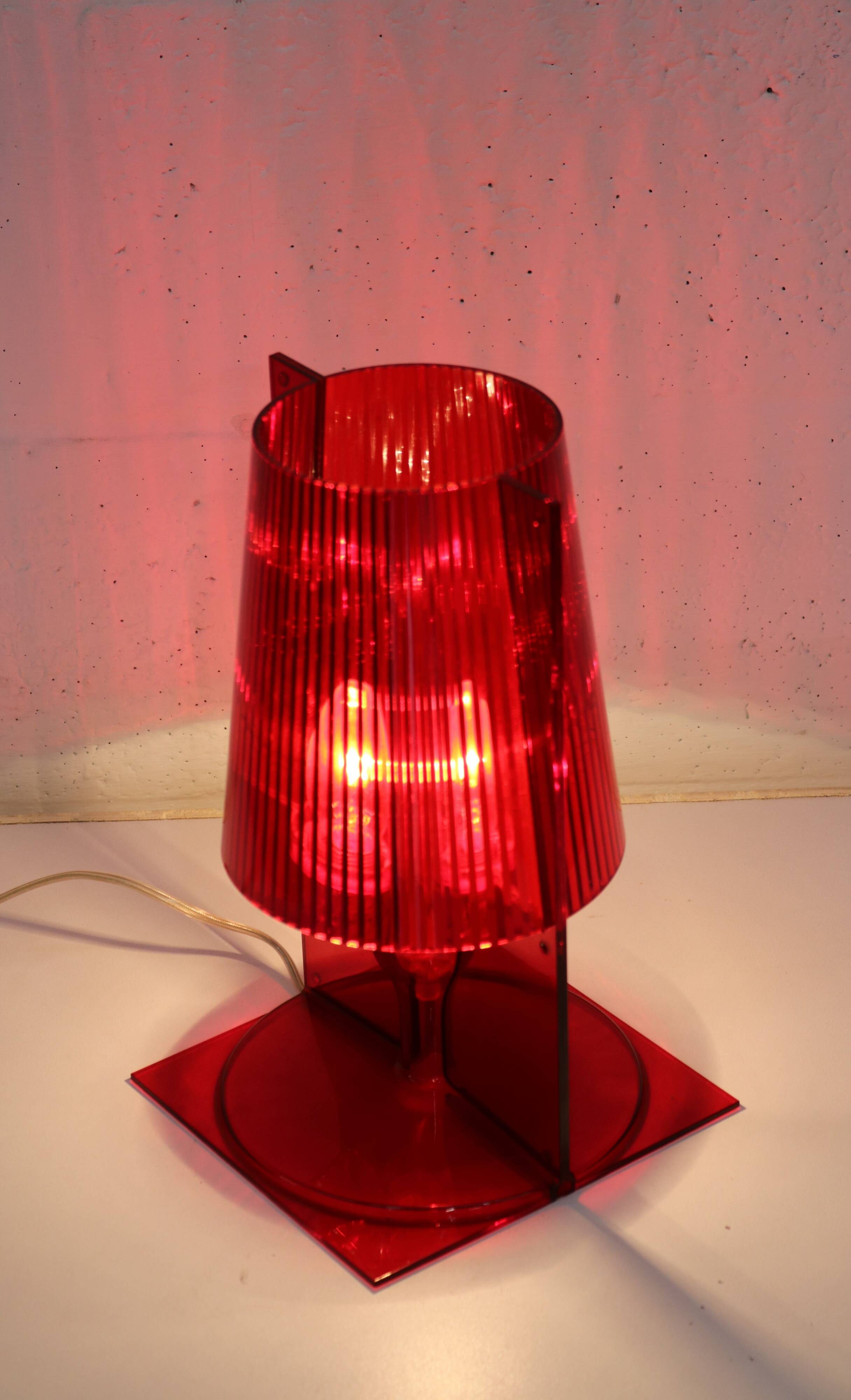 Red plastic Kartell table lamp - model Take - design by Ferruccio Laviani