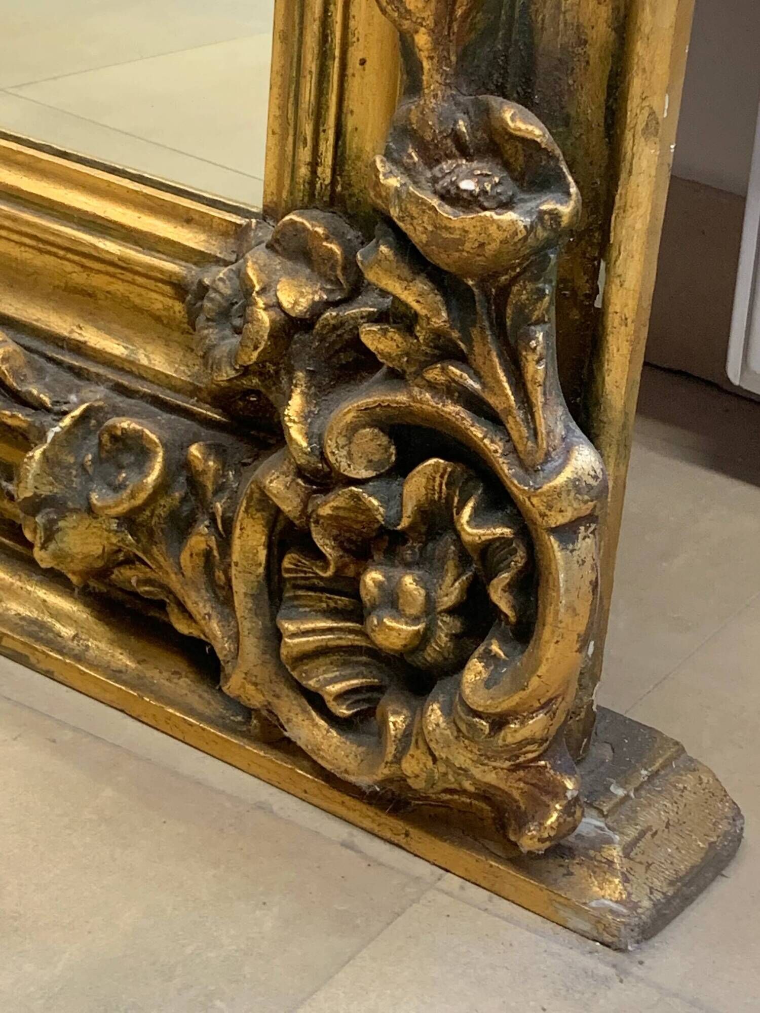 French palace mirror with bow and lion heads, gilded frame.