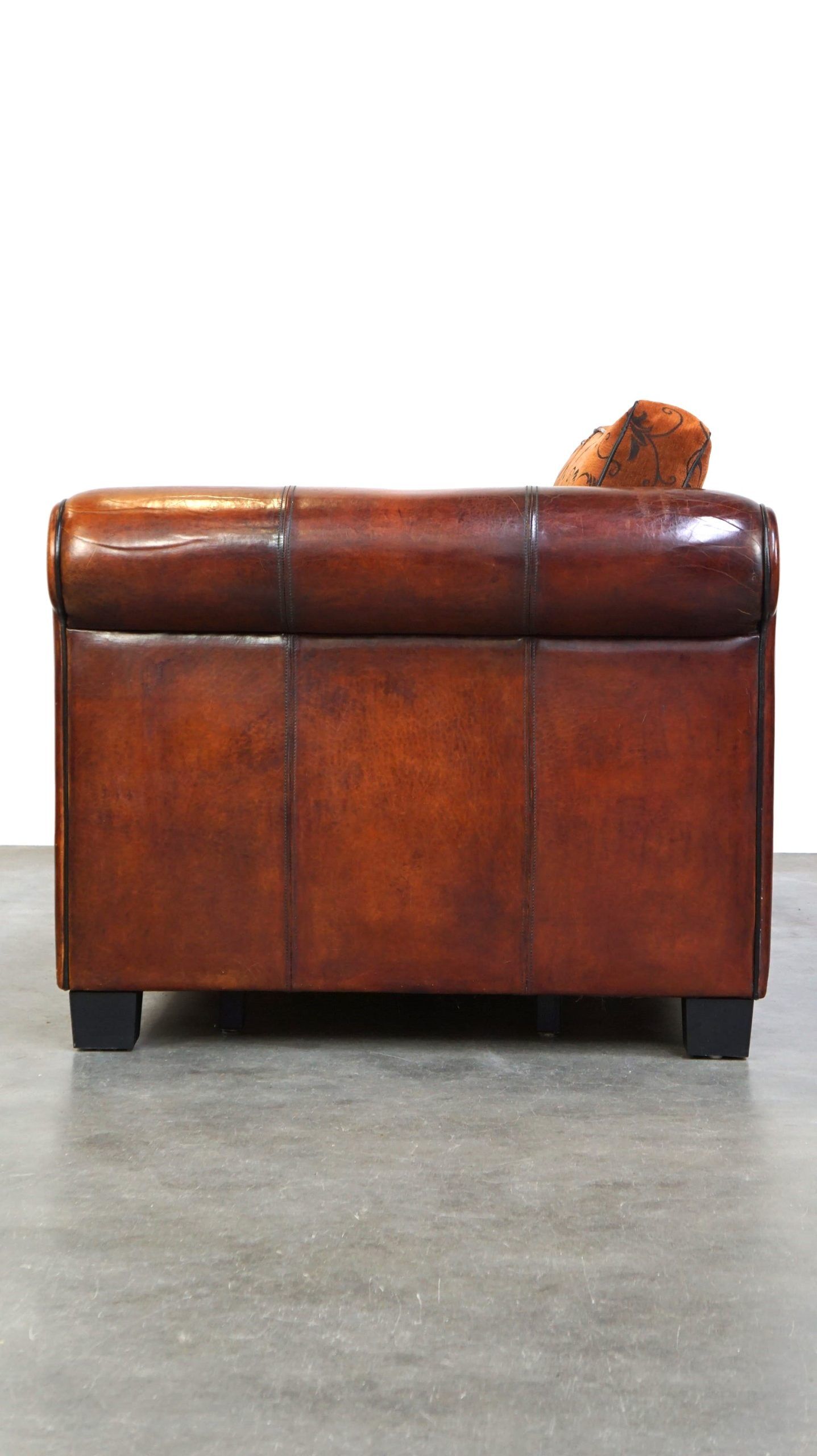 Canapé en cuir de mouton 2,5 places, luxueux et confortable, avec des coussins en tissu.