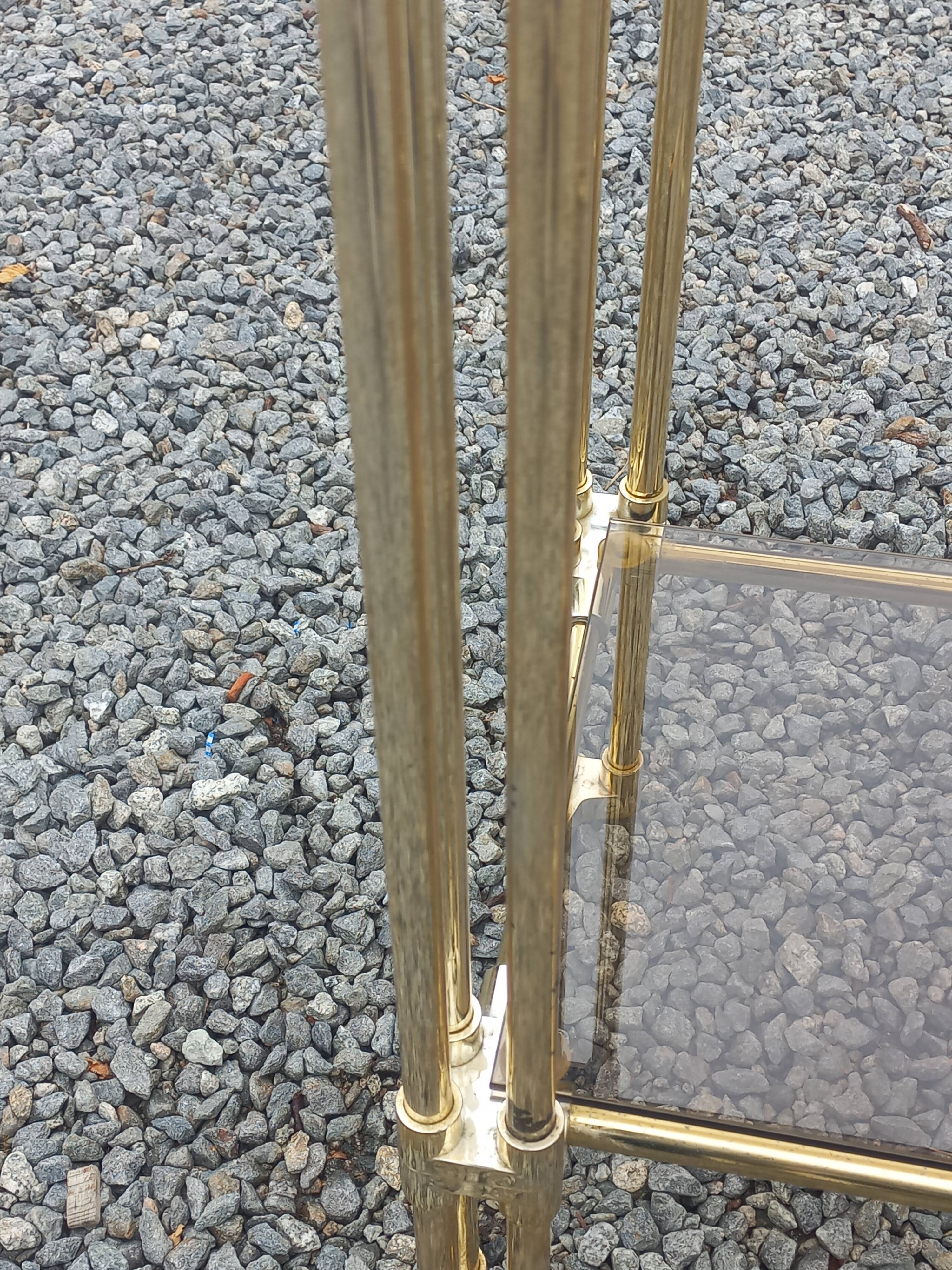 Pair of Hollywood Regency side tables in gold metal and smoked glass.