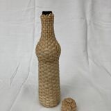 Bottle surrounded by wicker or raffia