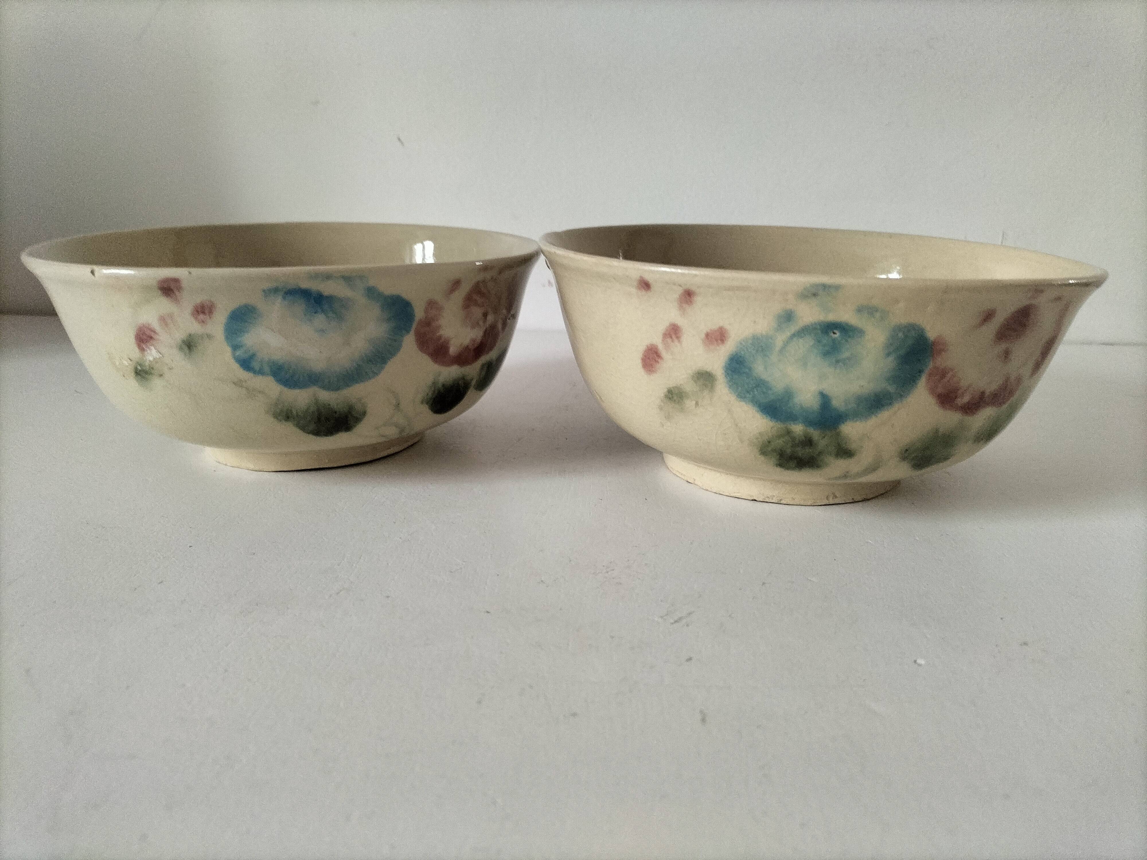 Two large vintage bowls in pastel decor on mini pedestals.