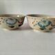 Two large vintage bowls in pastel decor on mini pedestals.