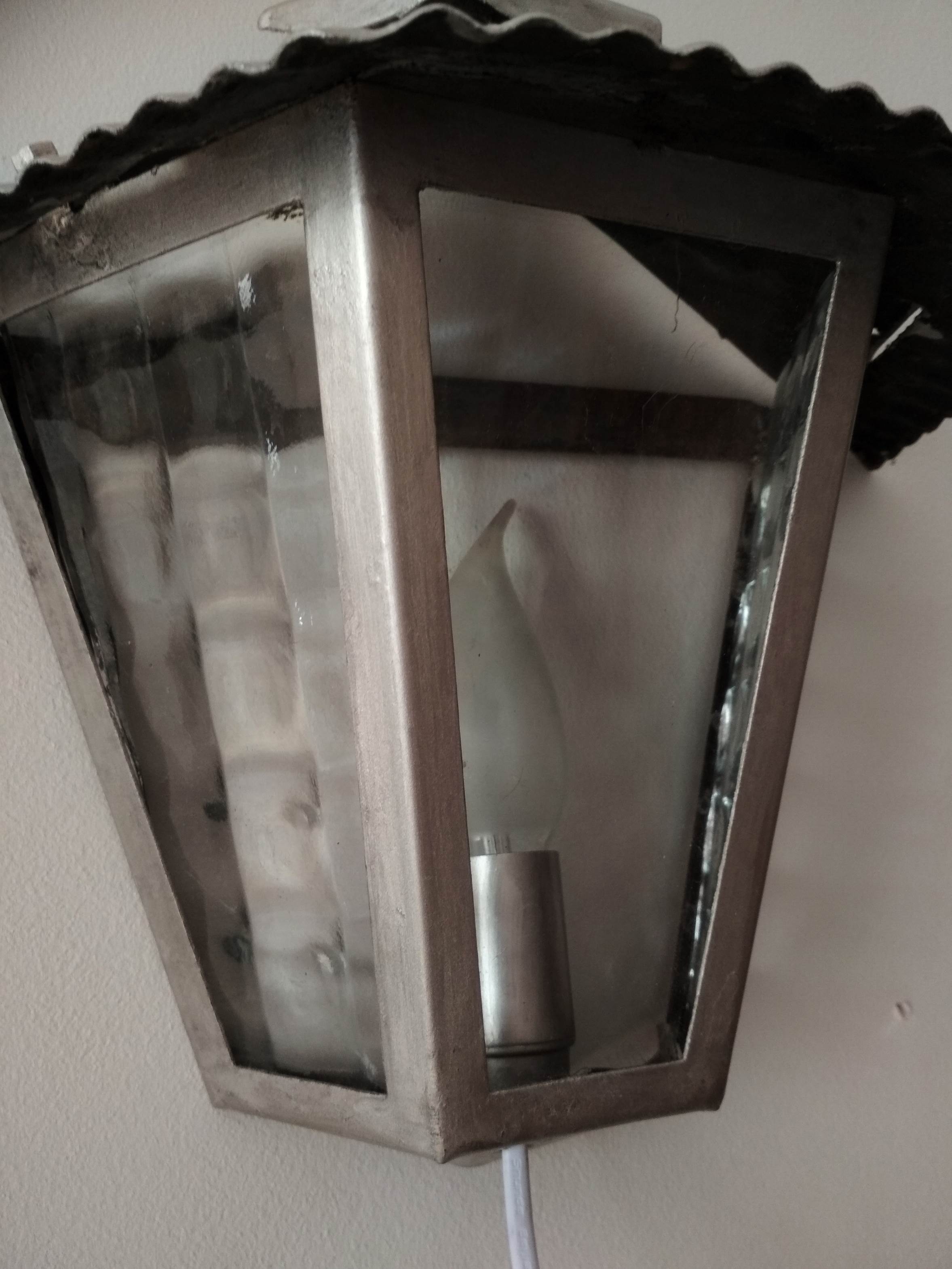 Half grey metal wall sconce and 3 windows