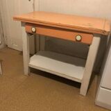 Vintage wooden kitchen table in orange and white with a drawer and low shelf.