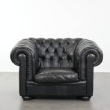 Comfortable black chesterfield armchair made of cowhide leather
