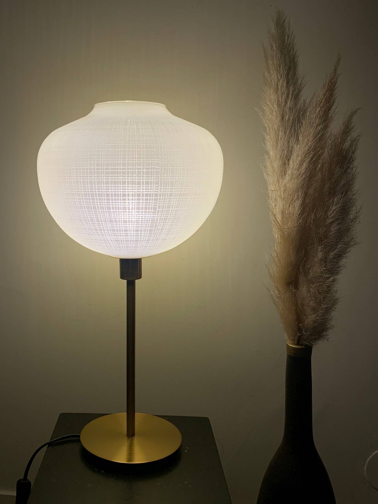 Table lamp with a white striped glass globe lampshade and a gold base
