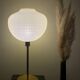 Table lamp with a white striped glass globe lampshade and a gold base