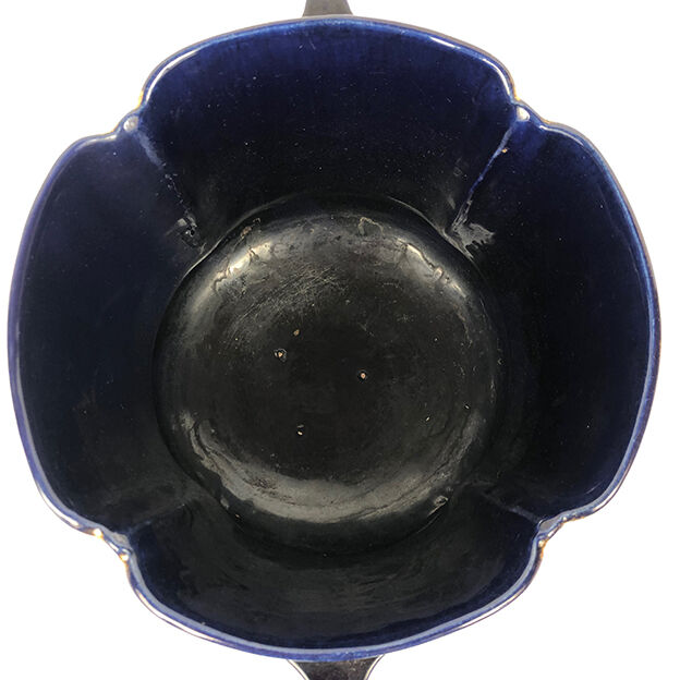 Large earthenware pot cover with enamelled decoration on a blue oven background