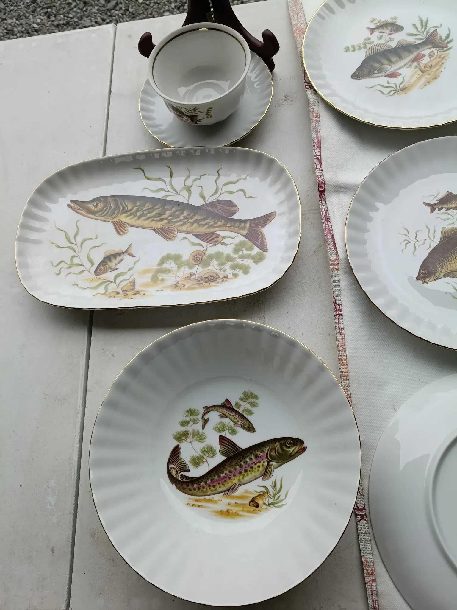 vintage porcelain dinner service with fish pattern and gold trim