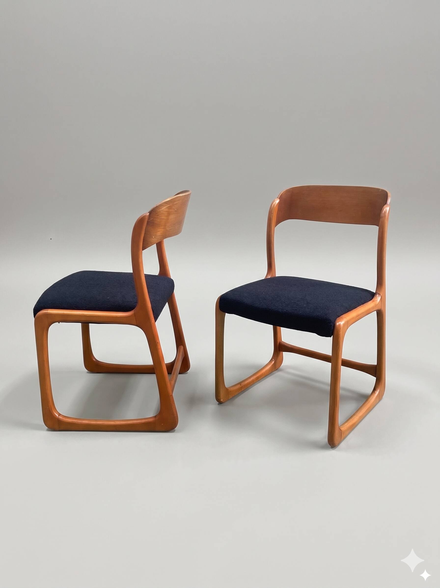Pair of vintage Baumann sled chairs with curved wood in honey colour.