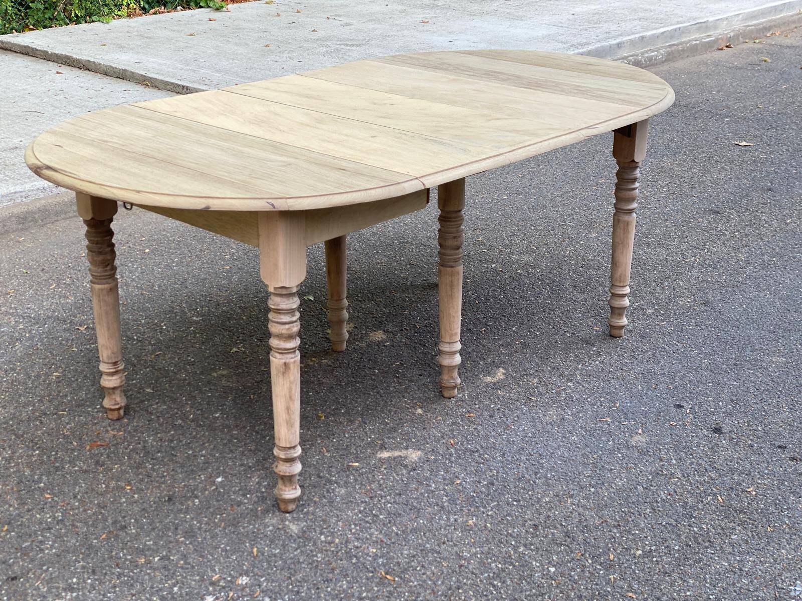 Round extendable dining table with flaps, stripped in raw oak, with 3 extensions.