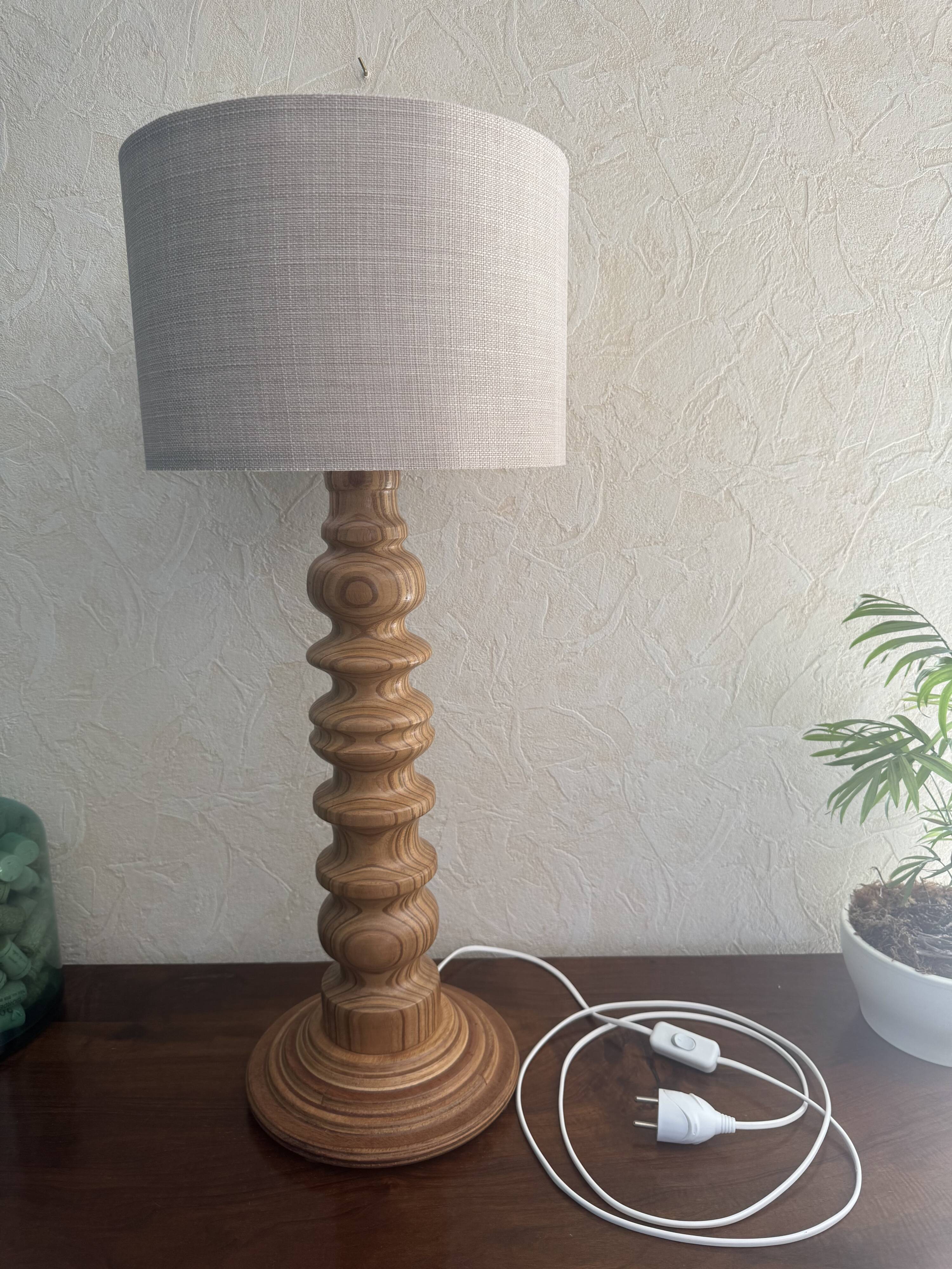 Wooden turned totem lamp with a linen shade in a vintage Scandinavian style.