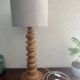 Wooden turned totem lamp with a linen shade in a vintage Scandinavian style.