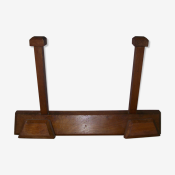 Wall-mounted coat holder has four patères