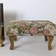 Large vintage upholstered footstool with curved legs.