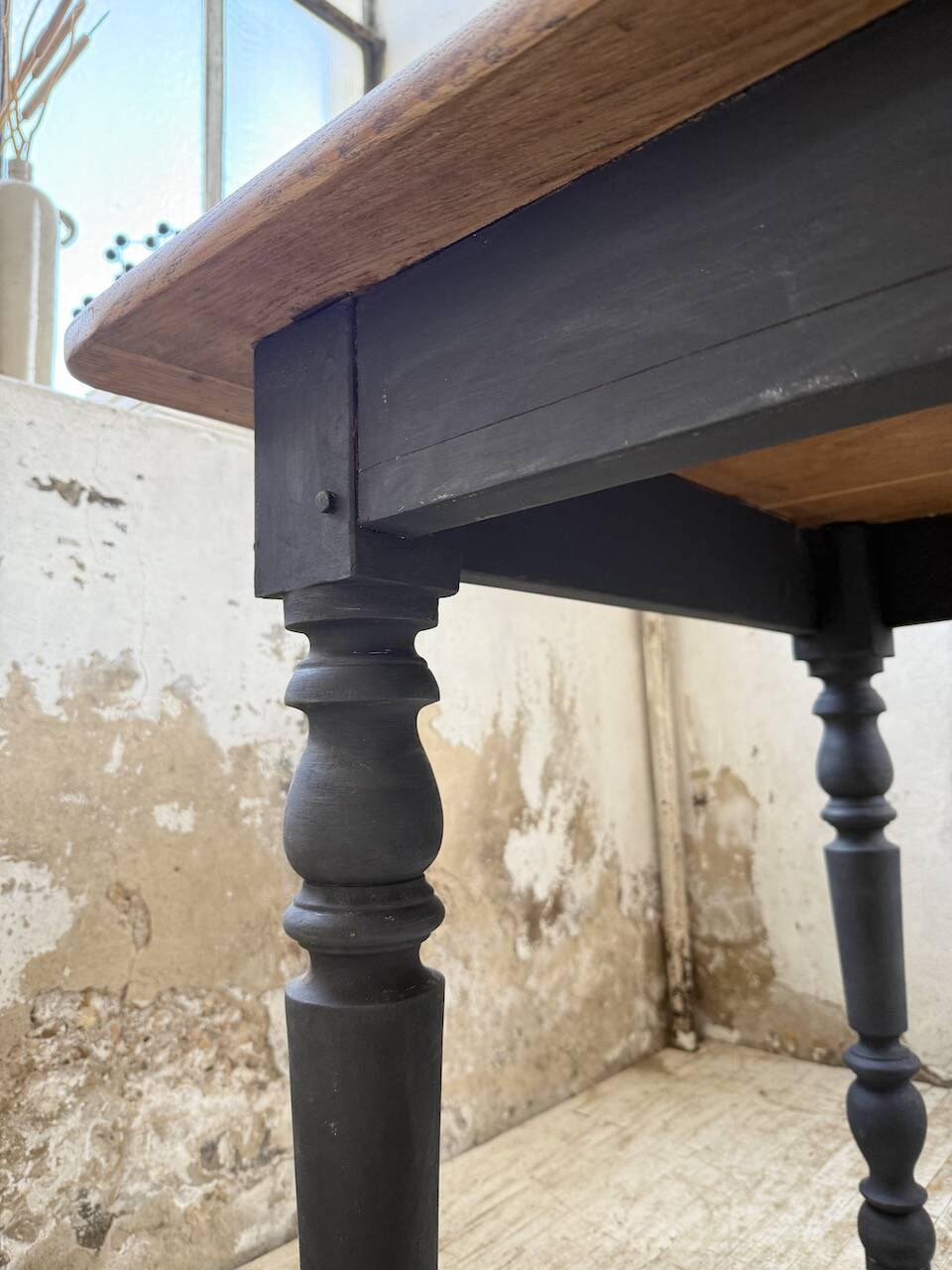 Oak farmhouse table with turned black legs.