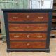 Vintage commode revamped in matte black & wood with warm tones.