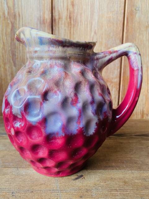Old pitcher in burgundy ceramic