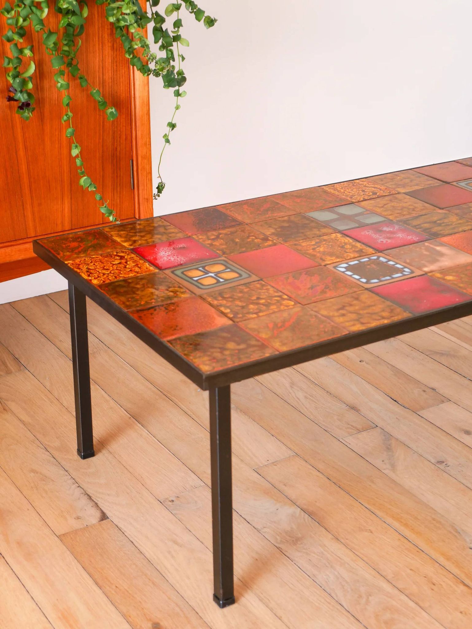 Ceramic and black iron coffee table, attributed to the Roche-Bobois brand, with a black metal base and structure, rectangular ceramic top from Vallauris with colourful patterns in ochre and orange, design from the 1970s.