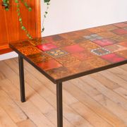 Ceramic and black iron coffee table, attributed to the Roche-Bobois brand, with a black metal base and structure, rectangular ceramic top from Vallauris with colourful patterns in ochre and orange, design from the 1970s.