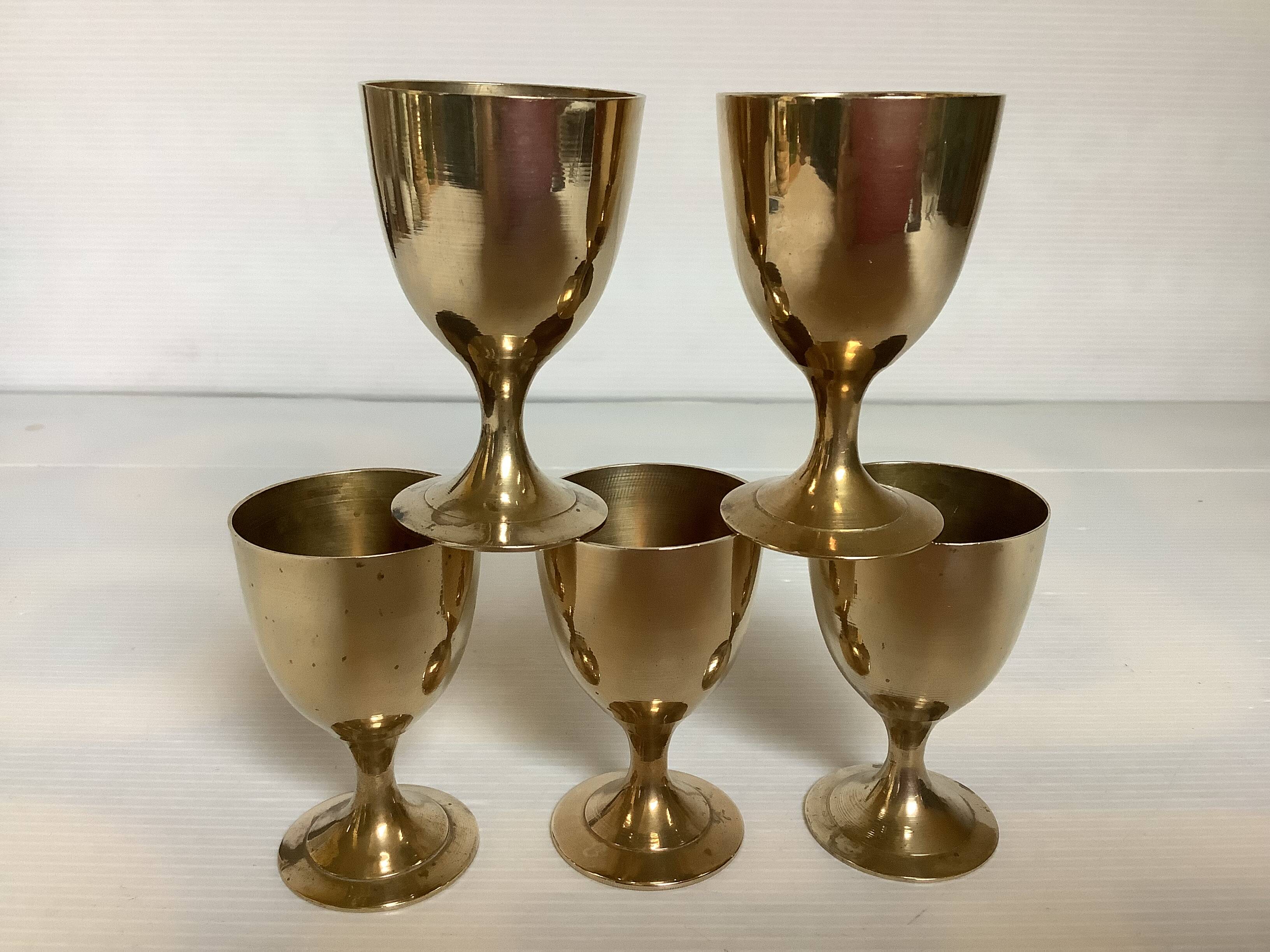 Five brass egg cups