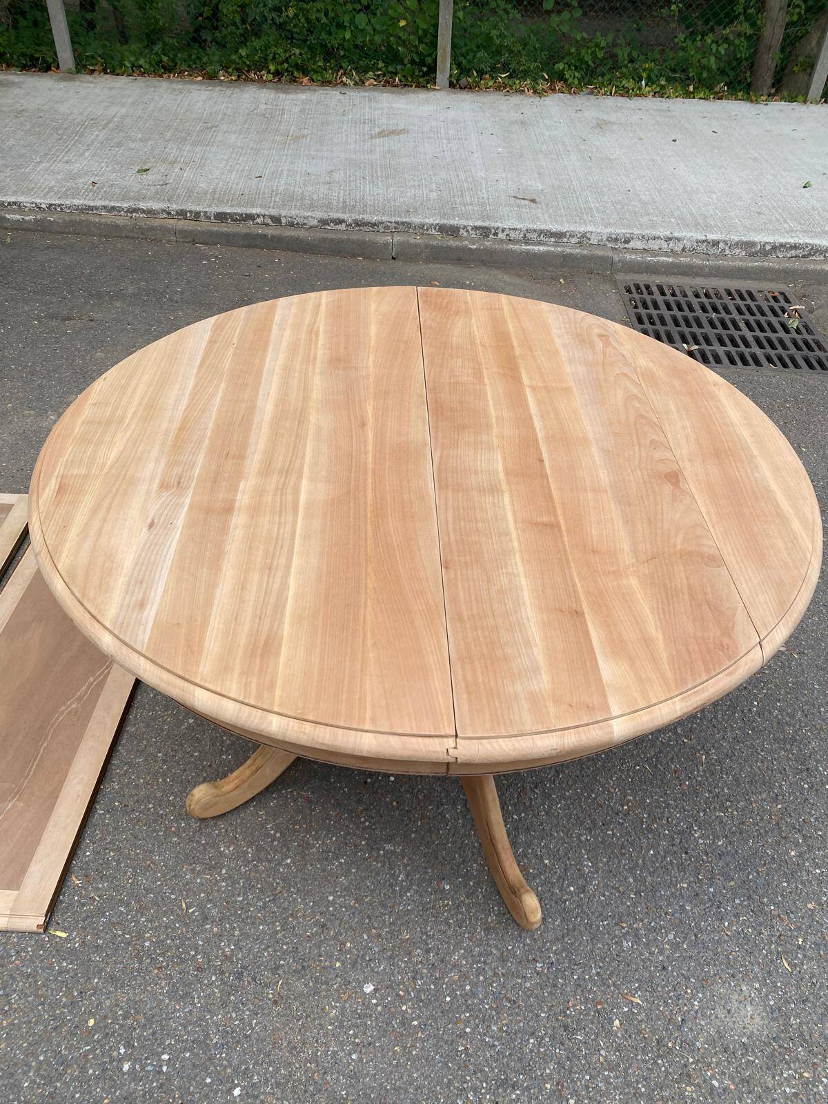 Round dining table with a central pedestal, extendable, stripped in solid walnut with 2 extensions.