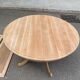 Round dining table with a central pedestal, extendable, stripped in solid walnut with 2 extensions.