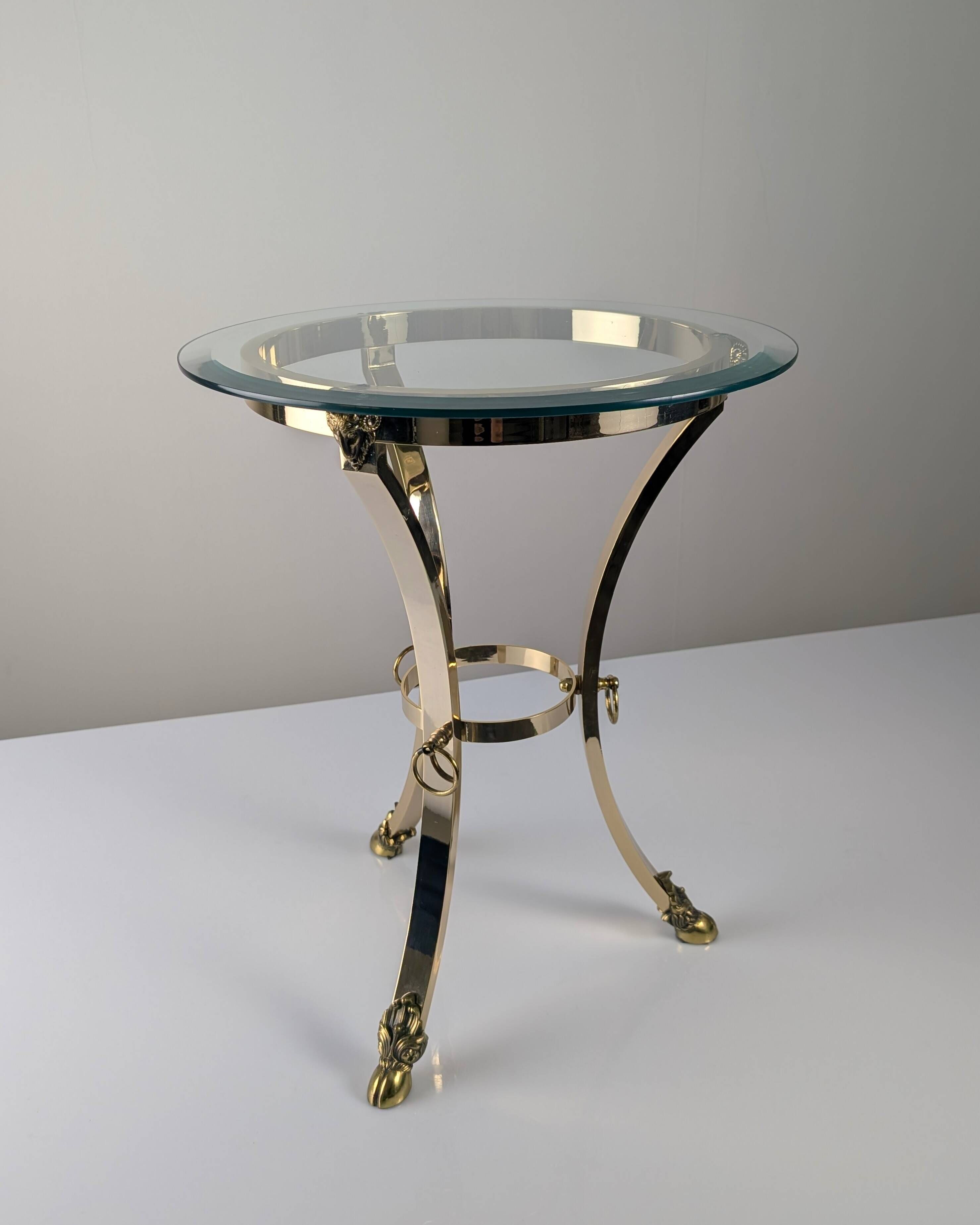 Neoclassical side table in brass and bevelled glass with ram's heads, 1970s.