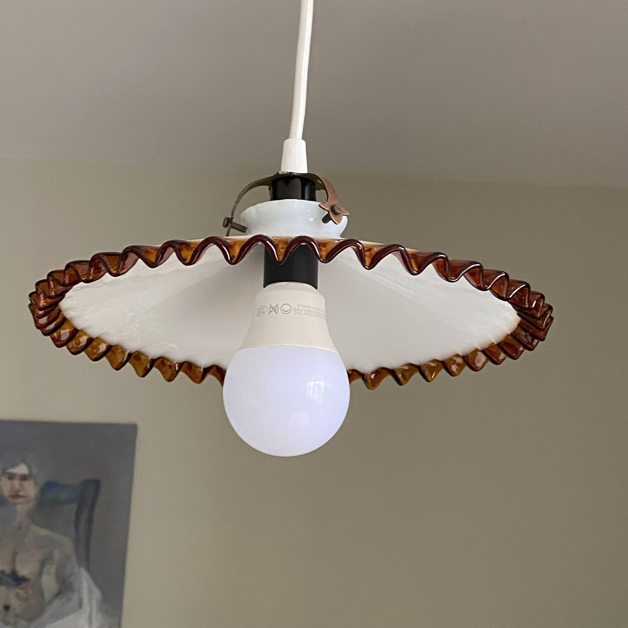 Old pendant light with a white opaline glass shade and a wavy border.
